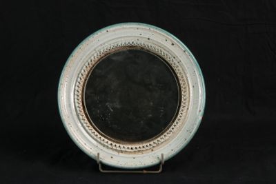 a white plate with a mirror on it on a black background