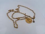 a close up of a gold chain with a coin on it