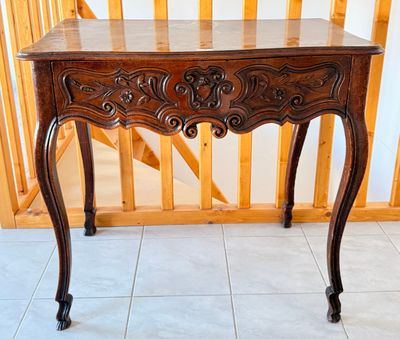 une table en bois avec un plateau en marbre, posée sur un sol carrelé