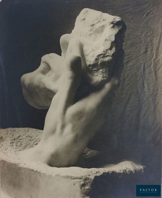 une vieille photo en noir et blanc représentant la sculpture d'un homme tenant un caillou
