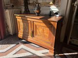 a large wooden cabinet with a vase on top of it