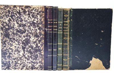 trois livres sont empilés sur une surface blanche