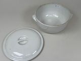 a white bowl with a lid sitting next to a white bowl with a lid