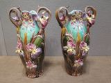 two vases sitting on a table with flowers painted on them