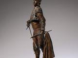 bronze statue of a man with a sword and a cape