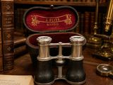 two binoculars sitting on top of a table next to a book