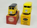 two yellow toy buses sitting next to each other on a box