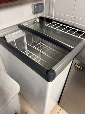 a sink with a metal counter top and a metal trash can