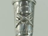 a silver cup on a black stick with a skull and crossbones on it