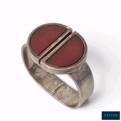 bague en argent massif avec une pierre rouge au centre et un anneau arrondi