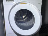 a white washing machine sitting next to a stack of dryers