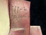 a close up of a sculpture of a person ' s head on a piece of wood