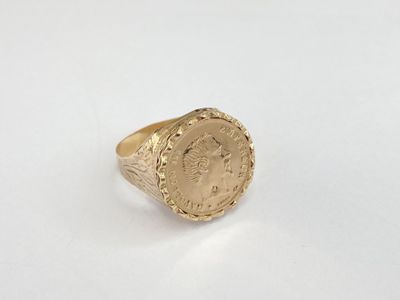 a gold ring with a roman coin on it