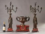 three candlesticks and a wine bottle on a table