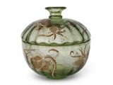 a green glass jar with a floral design on it