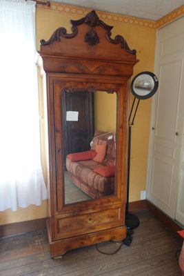 un grand miroir dans un coin de la pièce, à côté d'un canapé