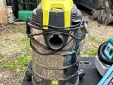un aspirateur posé par terre à côté d'un ordinateur portable