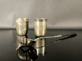deux tasses et cuillères en argent posées sur une table noire