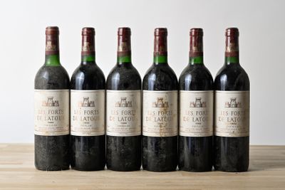 six bottles of wine are lined up on a wooden table