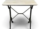 une table en marbre blanc avec des pieds en fer, sur fond blanc