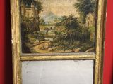 painting of a landscape in a gold frame on a red wall