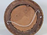 a brown plate with a wire in it on a white surface