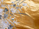 a close up of a gold fabric with flowers on it