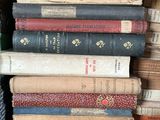 books stacked on top of each other on a shelf in a room