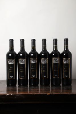 six bouteilles de vin sont alignées sur une table en bois