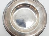 une assiette ancienne en argent sur fond blanc