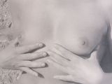 a black and white photo of a woman holding her hands on her chest