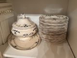 many plates and bowls sitting on a shelf in the kitchen