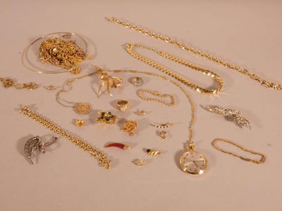 a lot of gold jewelry on a white table