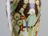 a vase with a bird design on it sitting on a table