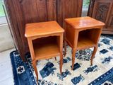 two small wooden tables on a rug in a room