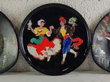three oval black plates with a picture of a woman and a man on a horse