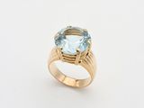 une bague en or sertie d'une topaze bleue au centre