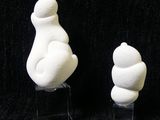 two white sculptures of a cat and a bear on a black background