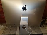 an apple computer sitting on a tiled floor in a room