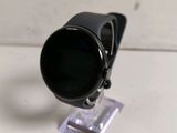 a black watch on a clear stand on a white surface