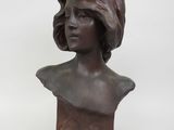 un buste en bronze représentant une femme coiffée d'un chapeau