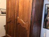 une grande armoire en bois dans le coin d'une pièce
