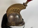 une image représentant un casque surmonté d'une plume rouge