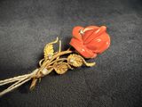 an image of a red flower brooch on a black background