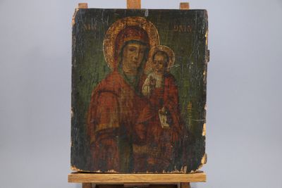 an old painting of a woman holding a child on a easel