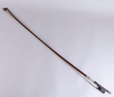 an old violin bow with a wooden handle on a white surface