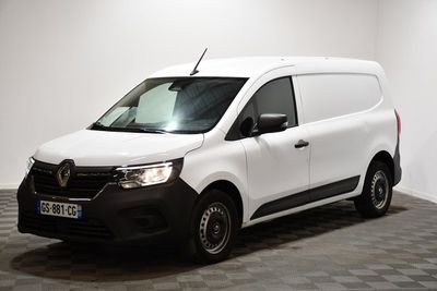 la camionnette blanche est garée dans une pièce au sol en damier