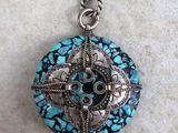 a close up of a necklace with a blue stone on it