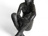 statue d'un homme assis à genoux sur un fond blanc