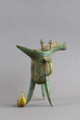 statue d'un homme tenant une banane à côté d'une petite figurine représentant un homme